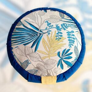 Cette image représente un zafu coussin de méditation petit modèle avec le contour bleu et une assise avec un imprimé floral sur fond argenté