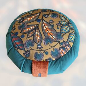Cette image représente un zafu coussin de méditation grand modèle avec le contour vert émeraude et une assise avec un imprimé floral et un fond marron clair en velours