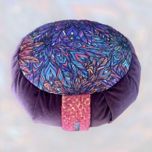 Cette image représente un zafu coussin de méditation petit modèle avec le contour violet et une assise avec un imprimé kaléidoscopique violet et bleu